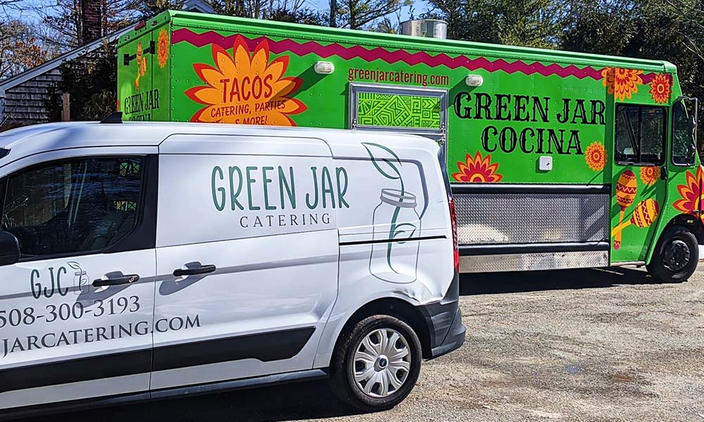 a white delivery van and green taco food truck from Green Jar Catering services