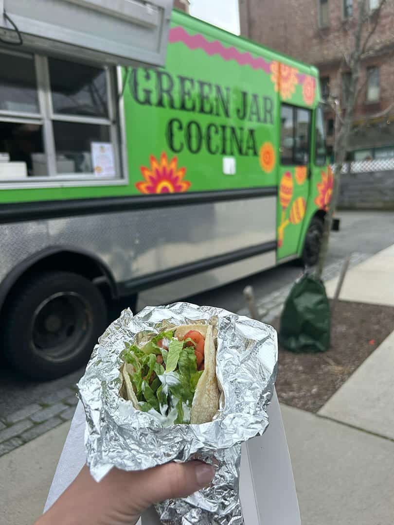 person showing gourmet taco purchased from food truck from Green Jar Catering services